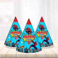 Blue cone hats with a skyline and yellow birthday name for a Spider-Man birthday party