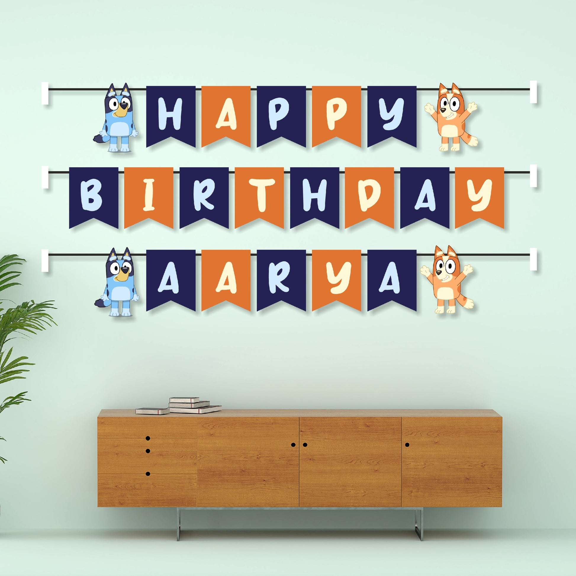 Bluey and Bingo personalised name bunting displayed as birthday party wall decoration above a cake table, custom flag banner for kids – BluParty India