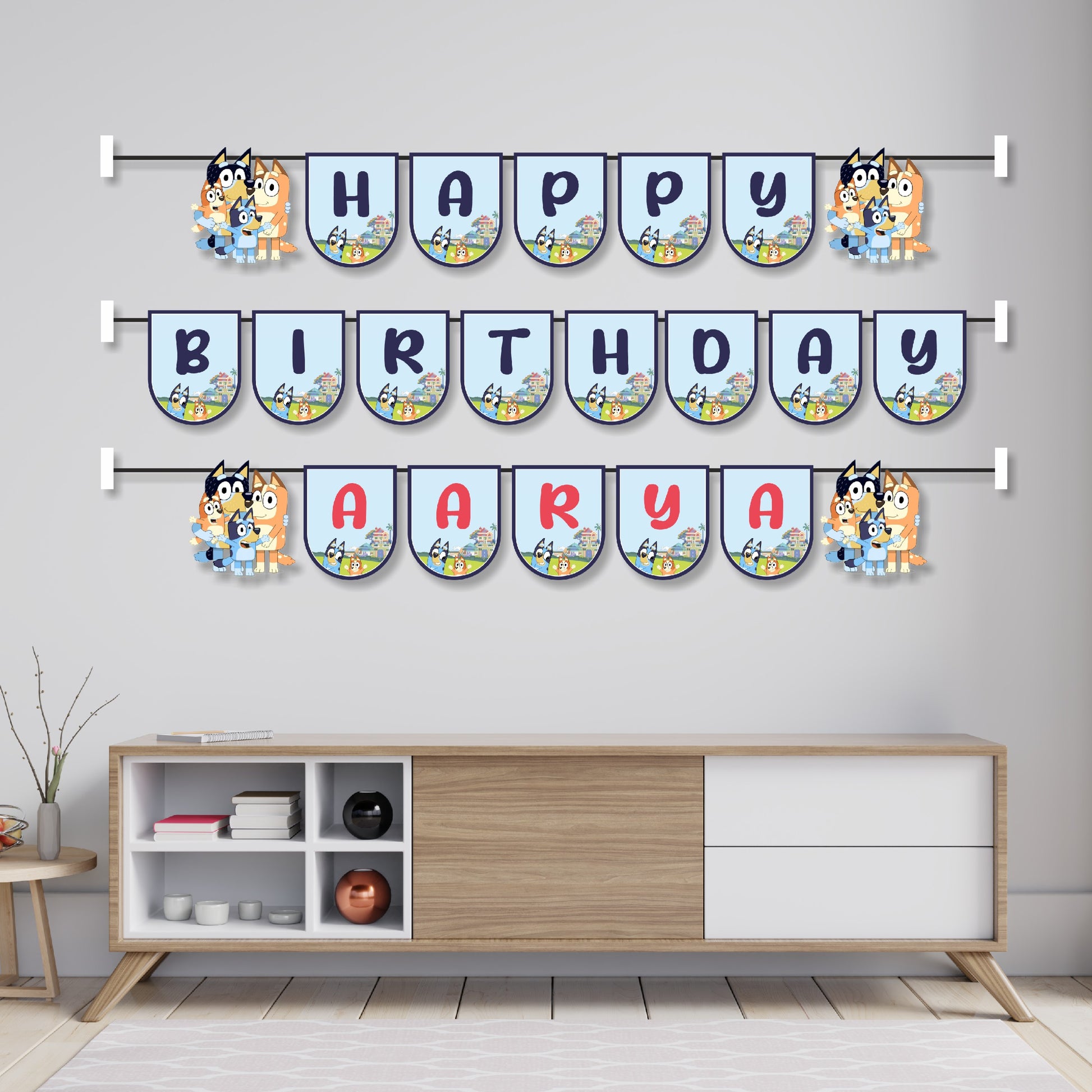 Bluey theme name bunting hung across a birthday party cake table as wall decoration, featuring Bluey and Bingo character flags spelling child's name – BluParty