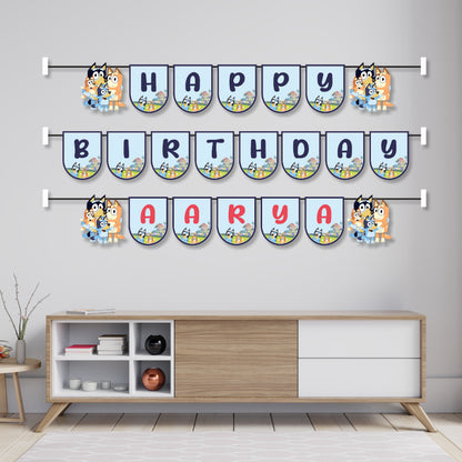 Bluey theme name bunting hung across a birthday party cake table as wall decoration, featuring Bluey and Bingo character flags spelling child's name – BluParty