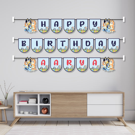 Bluey theme name bunting hung across a birthday party cake table as wall decoration, featuring Bluey and Bingo character flags spelling child's name – BluParty