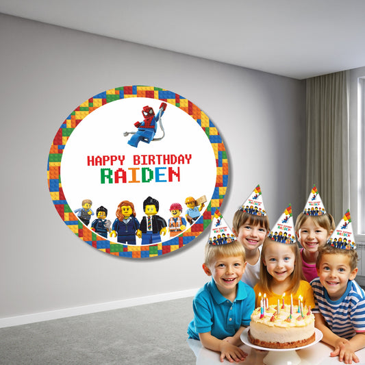 LEGO themed personalized circular birthday backdrop displayed behind a cake table with custom name and age as part of the brick design, styled with balloon garland for kids party

