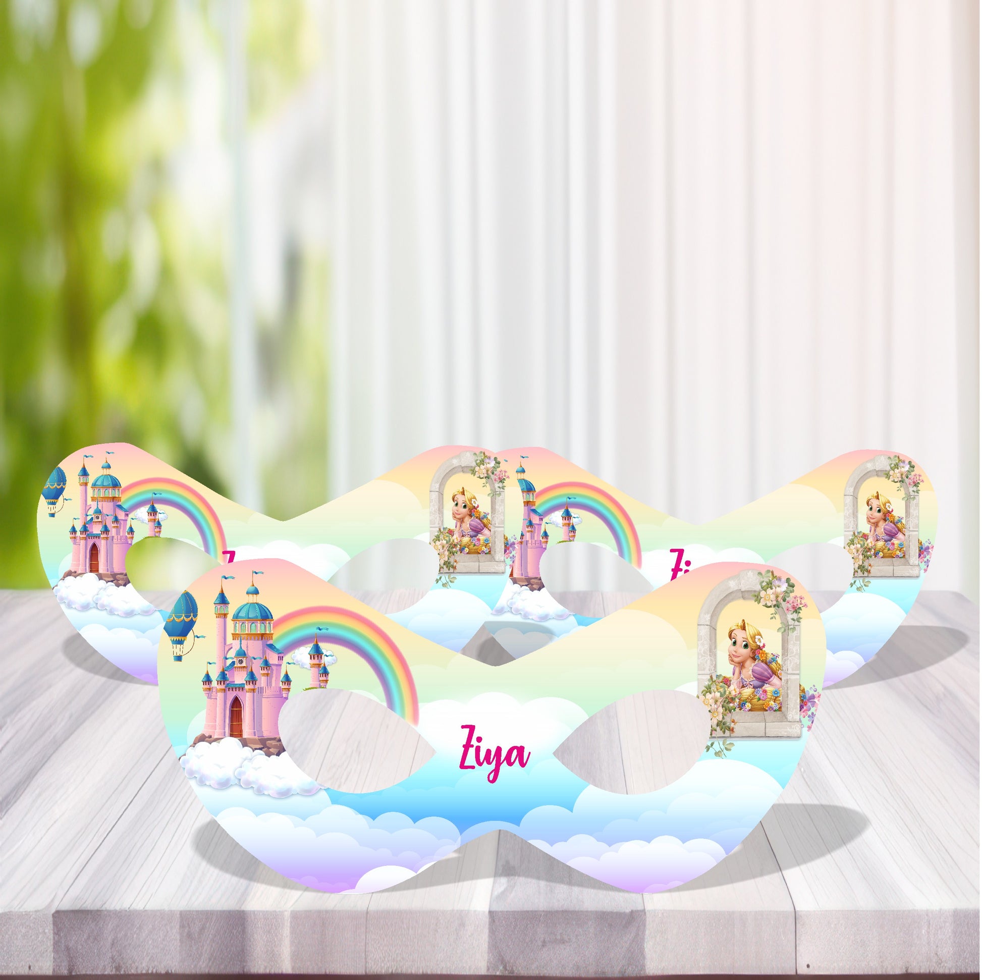 Princess theme personalized birthday name eye masks with royal crown design and child's name as central artwork displayed at girls birthday party celebration with pink gold balloon decoration India
